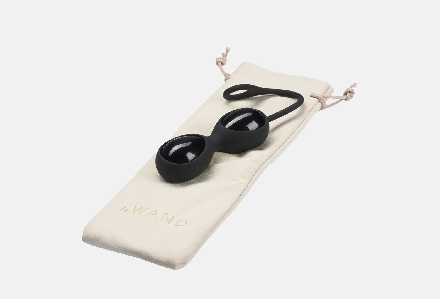 Ovos yoni de obsidiana de cor preta da marca Le Wand pousados em cima de uma bolsa de algodão