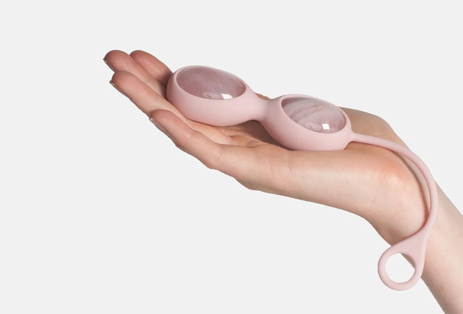 Ovos yoni de quartzo rosa de cor rosa da marca Le Wand — segurado na mão