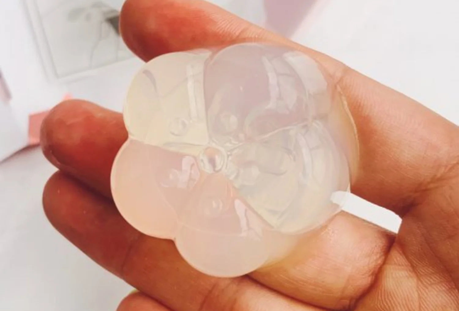 Estimulador clitoriano sem motor Iroha Petit Plum em silicone transparente — segurado na mão