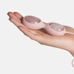 Ovos yoni de quartzo rosa de cor rosa da marca Le Wand — segurado na mão