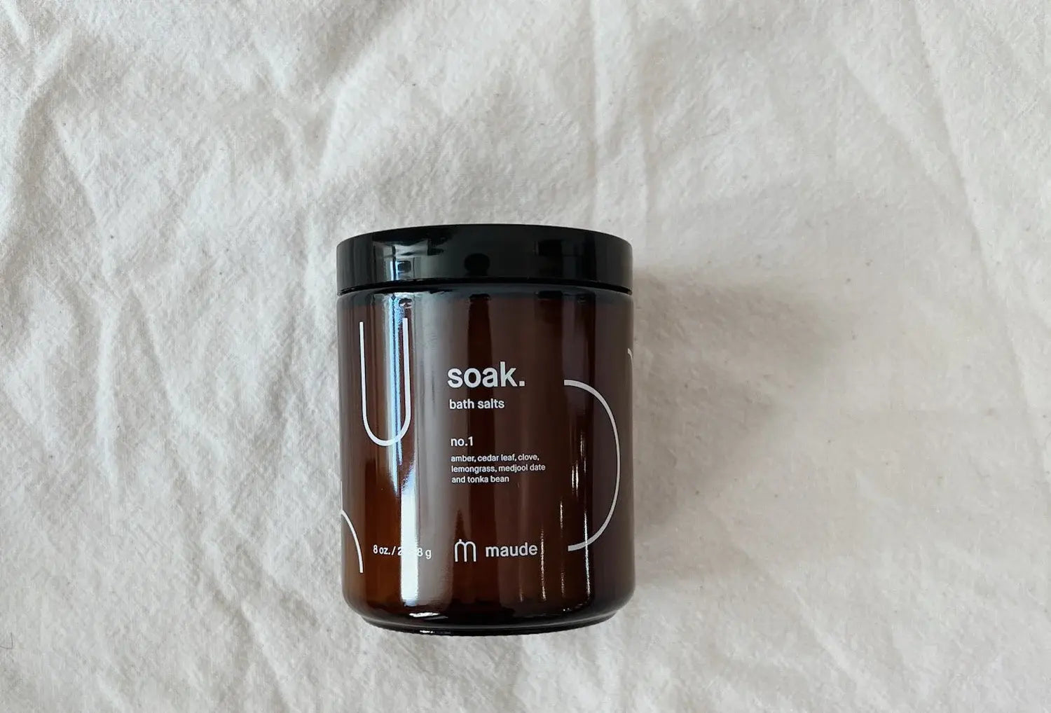 Sais de banho minerais Maude nº1, frasco 226 g em cima de um pano de linho cru