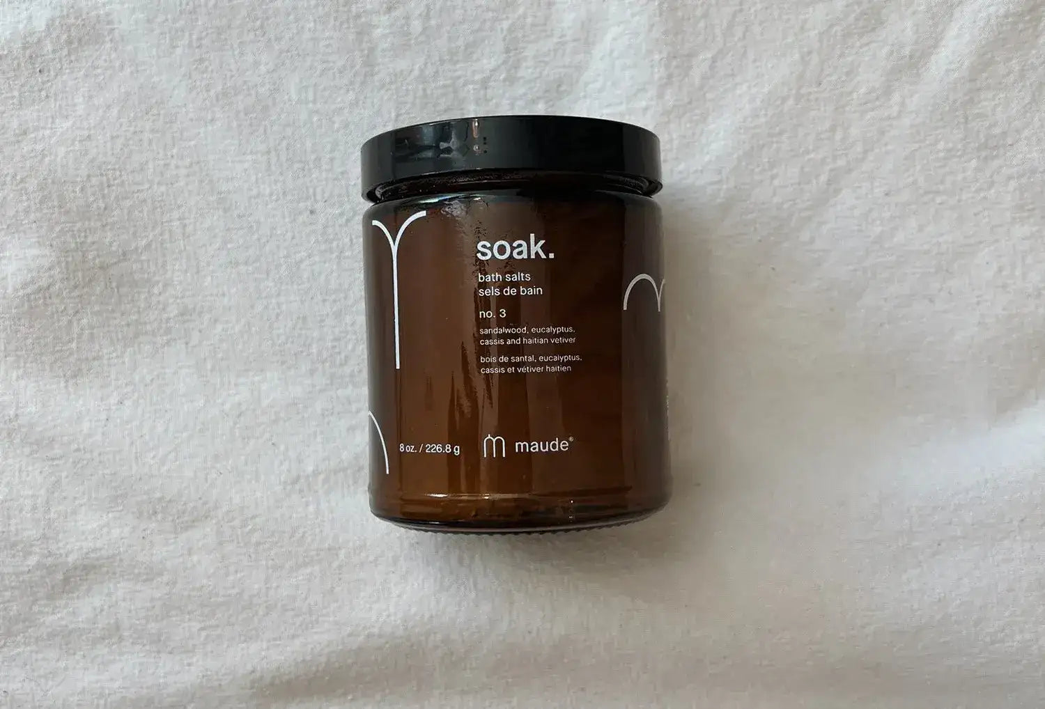 Sais de banho minerais Maude nº3, frasco 226 g em cima de um pano de linho cru