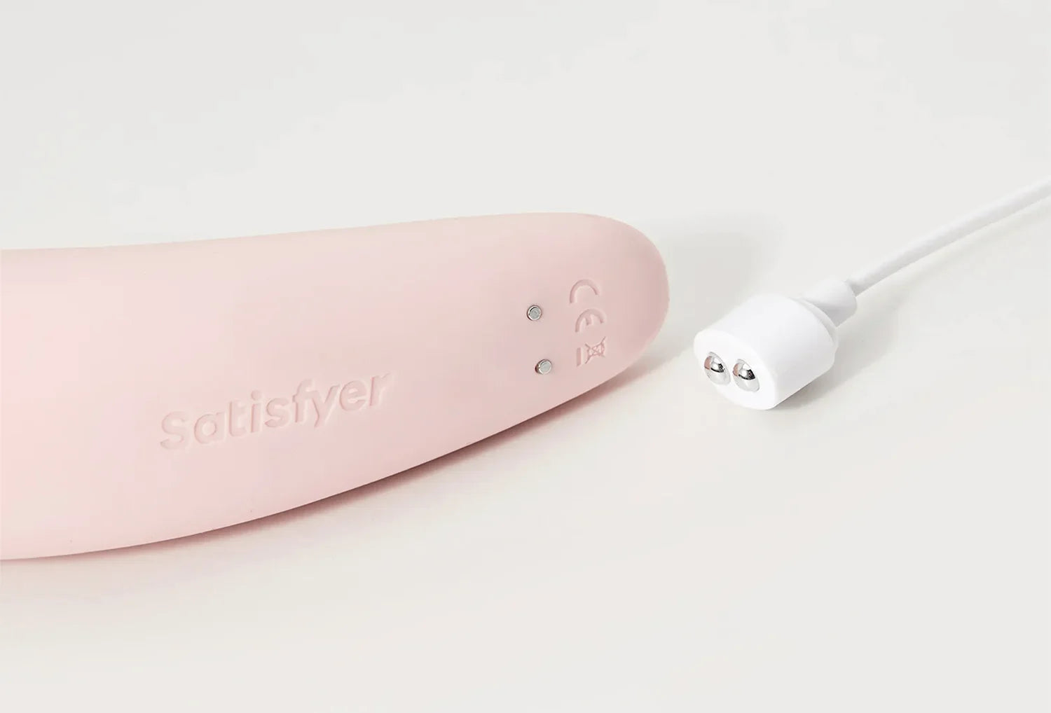 Sugador de clitóris Satisfyer Curvy 2+ em silicone de cor rosa claro — zoom da base com cabo usb