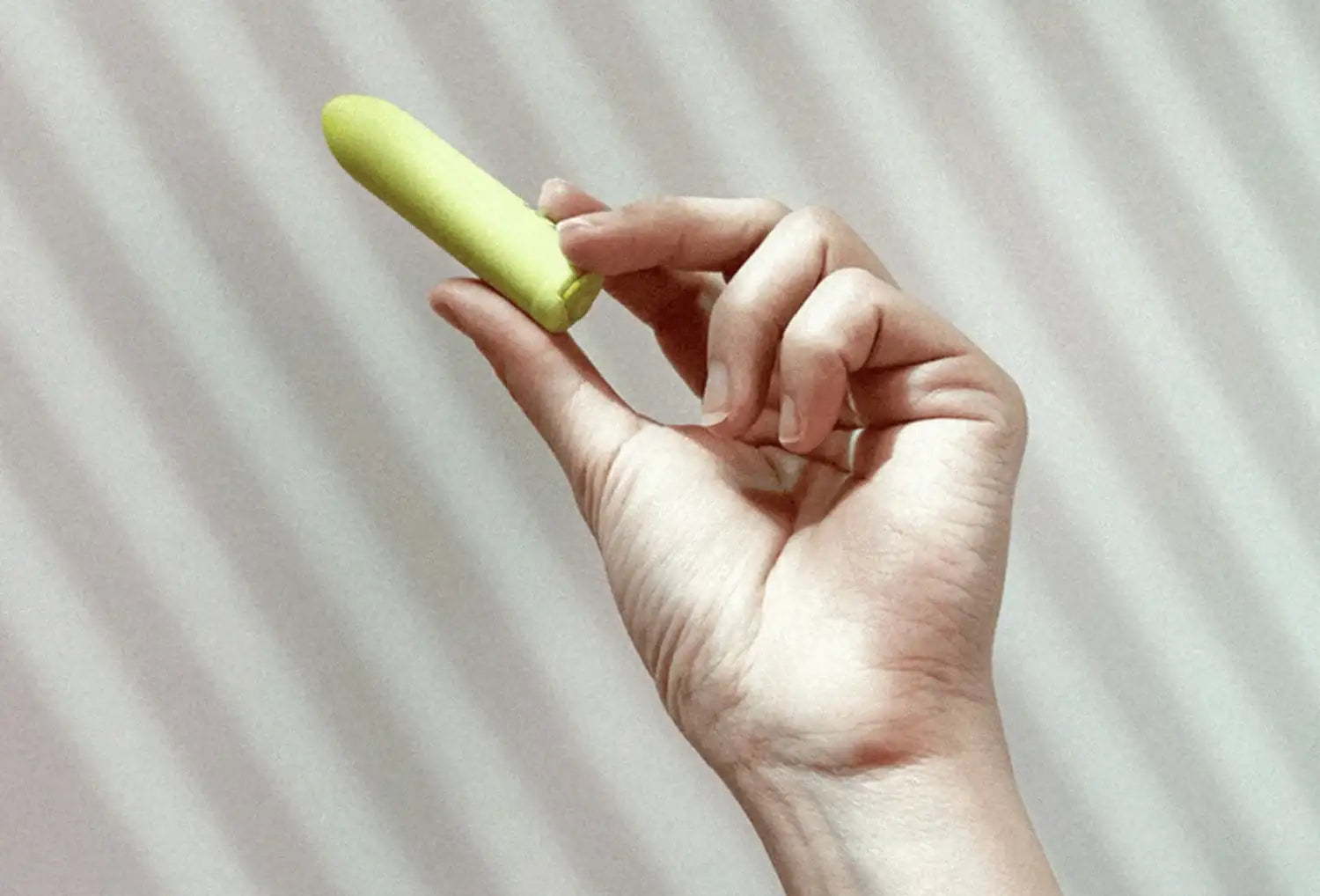 Vibrador bullet clitoriano Dame Zee em ABS de cor cítrico — segurado na mão