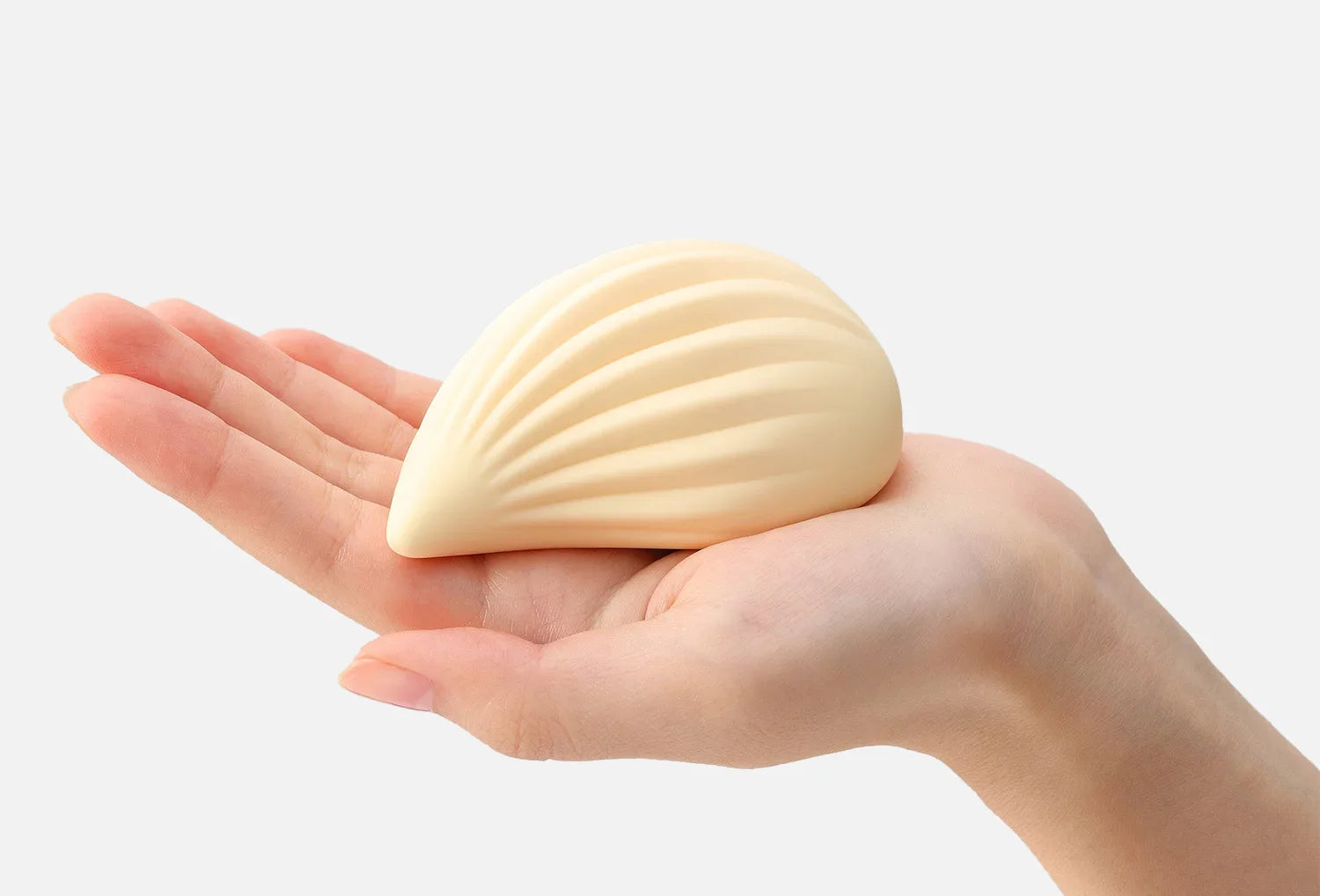 Vibrador clitoriano Iroha Kushi em silicone de cor marfim — segurado na mão