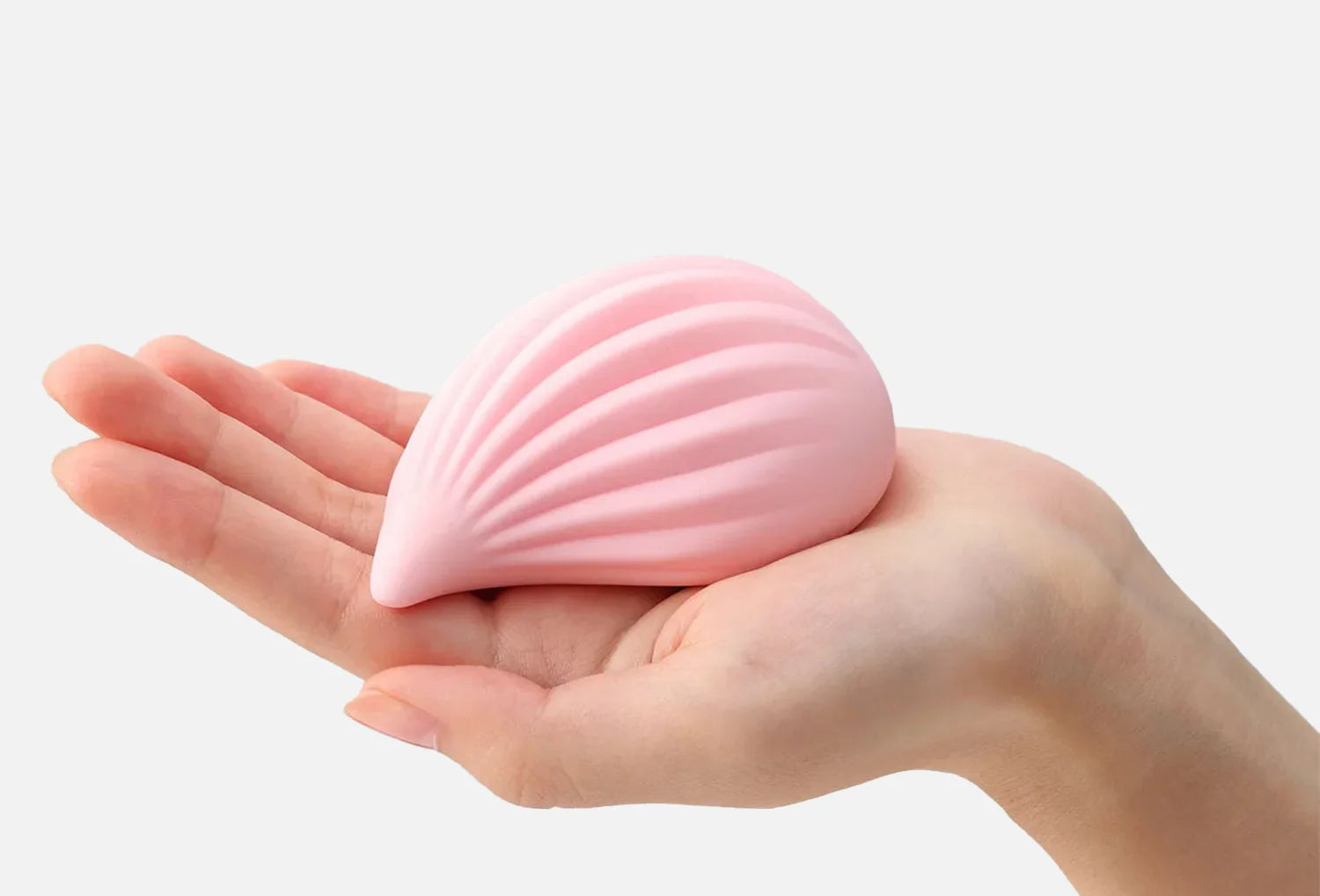 Vibrador clitoriano Iroha Kushi em silicone de cor rosa claro — segurado na mão