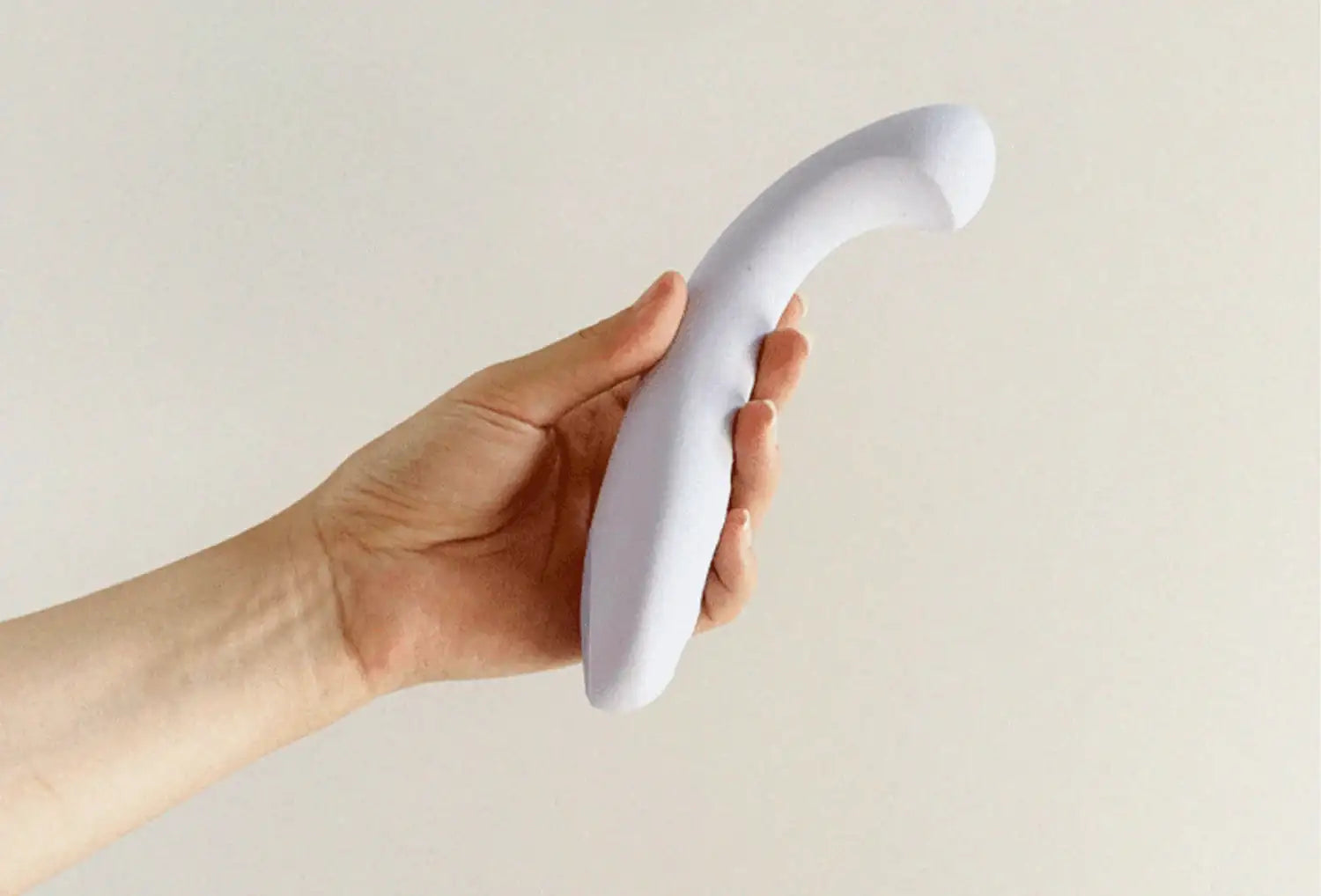 Vibrador de ponto g Dame Arc em silicone de cor lavanda — segurado na mão