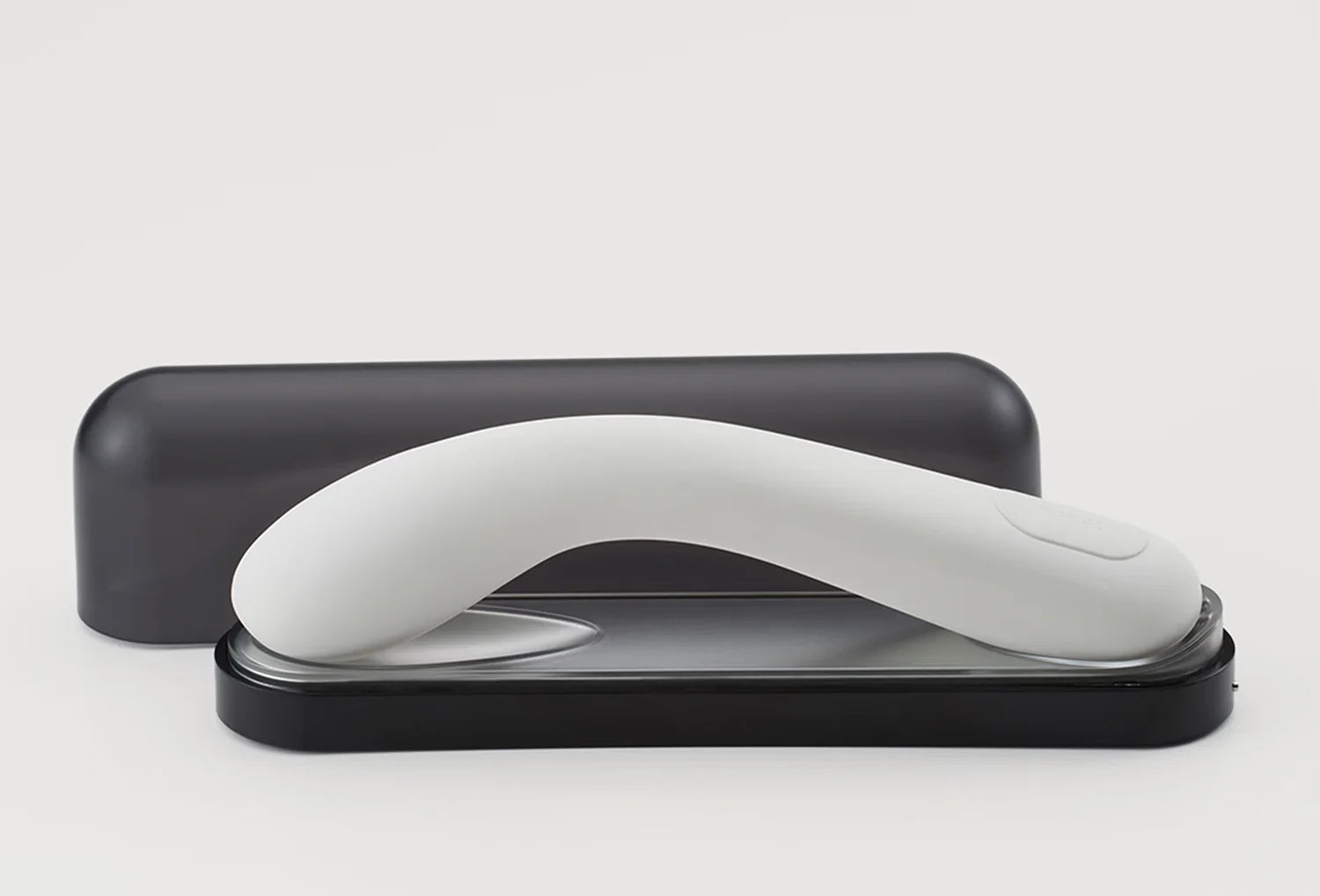 Vibrador de ponto g Iroha Mai em silicone de cor branco — vista lateral pousado na caixa de carregamento com tampa ao fundo
