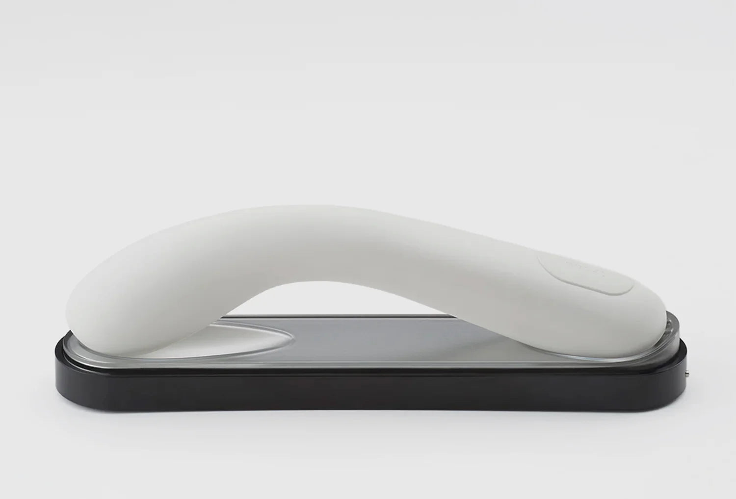 Vibrador de ponto g Iroha Mai em silicone de cor branco — vista lateral pousado na caixa de carregamento